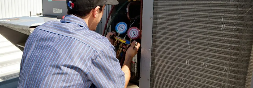 HVAC technician servicing a condenser unit in Green Oak