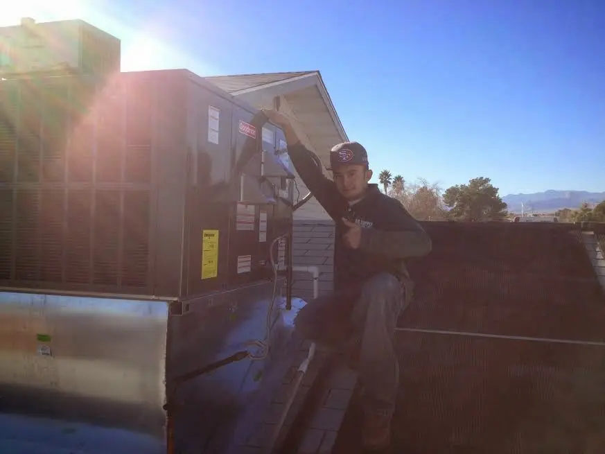 HVAC technician performing HVAC Inspection on a rooftop unit in Green Oak